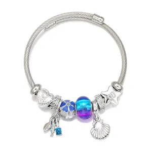 Bracelet charms en acier inoxydable avec perles en verre bleu et coquillage fin.