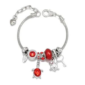 Silver-tone charm bracelet featuring red crystals, sea turtles, and a heart extension chain.