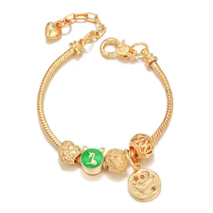 Detailed view of the gold-plated snake chain bracelet with zodiac charm and green bead.