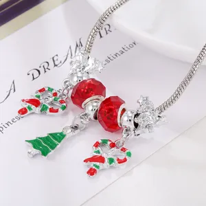 Christmas charm bracelet detail featuring red crystal beads and festive tree pendants.