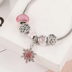 Vista dettagliata del bracciale in argento con perline di cristallo rosa e ciondolo.