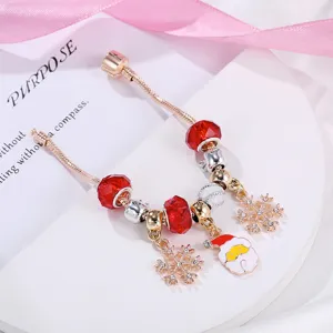 Bracciale natalizio in oro rosa con perline rosse, ciondoli a fiocco di neve e Babbo Natale.