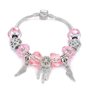 Hermosa pulsera de dijes plateada con cuentas de cristal rosa y hermosos dijes de plumas.