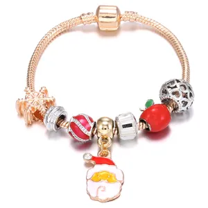 Gros plan détaillé du bracelet de Noël avec joli pendentif du Père Noël et perles rouges.