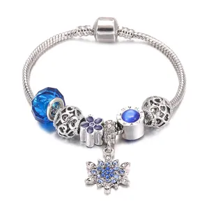 Vista dettagliata del bracciale a catena di serpente in argento con perline blu e ciondolo.