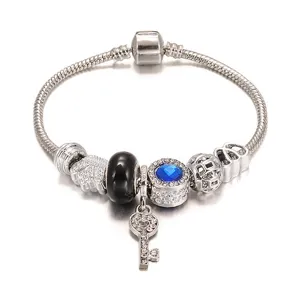 Zilveren bedelarmband met blauwe kristal, sleutelhanger en verschillende kralen voor dames.