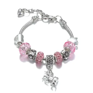 Dettaglio del bracciale con ciondoli in argento, perle di cristallo rosa e unicorno.