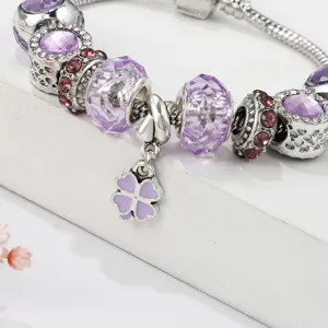 Detailed view of the purple clover charm bracelet, featuring sparkling beads and silver snake chain.