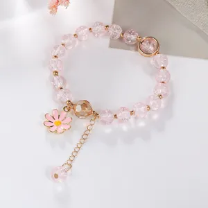 Pink crackle crystal bracelet detail showing daisy pendant and gold beads close up view