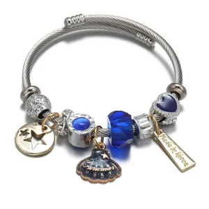 Edelstahl Charm Armband Detail Nahaufnahme mit blauen Perlen und Muschel Anhängern.