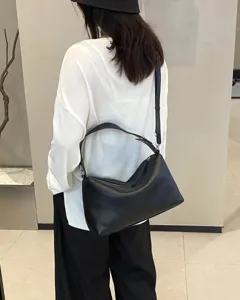 Minimalist genuine leather hobo shoulder bag detail view, sleek black daily crossbody purse.