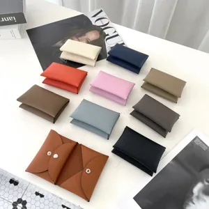 Detailed showcase of colorful genuine leather card holders and purses on white table.