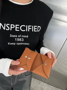 Detailed view of the brown leather envelope card holder with snap button design for daily use.