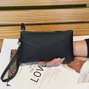 Genuine leather wristlet clutch bag for women, stylish black envelope purse with zipper and strap.