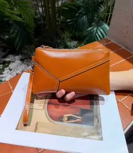 Vintage genuine cowhide leather women clutch bag with stylish white stitching and wrist strap.
