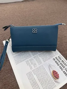 Blauer Umhängebeutel aus Leder mit Klee-Metall-Logo für den lässigen täglichen Gebrauch.