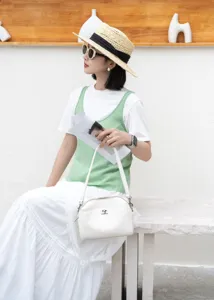 Elegant white leather shoulder bag for women, stylish baguette handbag with metal lock closure.