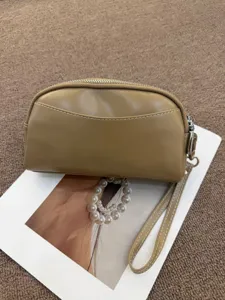 Detailed close-up view of simple minimalist women's leather clutch bag in khaki color.