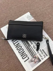 Detailaufnahme der schwarzen Texturtasche mit weißer Ziernaht und silbernem Metallbeschlag.