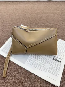Vintage genuine leather clutch bag detail shot, brown wristlet wallet with secure zipper.