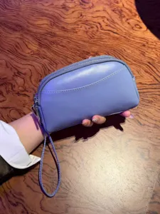 Minimalist leather wristlet bag for women, versatile double zipper coin purse and phone clutch.