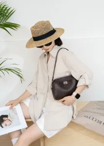 Close-up detail of dark brown genuine leather underarm shoulder bag with metal turn-lock.