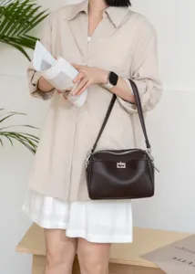 Brown leather underarm shoulder bag with metal turn-lock closure and zipper for daily commute