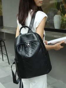 Detail shot of black leather quilted backpack worn by model, showing casual everyday style.