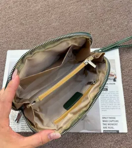 Semi-circular genuine leather clutch cosmetic bag with multi-compartments and zipper.