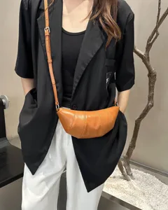 Detailed view of stylish genuine leather croissant crossbody bag for women, chic design.