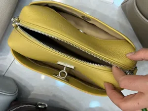 Yellow genuine leather shoulder bag with chic lock closure and metal zipper detail stylish.