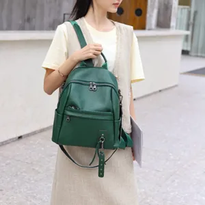 Detailed view of the dark green genuine leather women backpack with stylish zippers and straps.