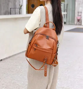 Detailed view of women brown leather backpack showing texture, zippers and stylish design.