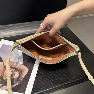 Leather crossbody bag interior detail showing spacious compartment, soft lining, and zipper.