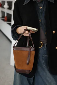 Vista dettagliata di una borsa a secchiello bicolore, elegante borsa per cellulare chic.