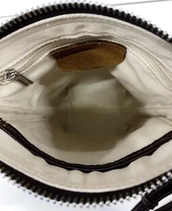 Vista dettagliata interna della borsa minimalista in tela con tasca con zip ed etichetta in pelle.