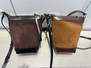 Primo piano sui dettagli della borsa a secchiello bicolore elegante, design casual.