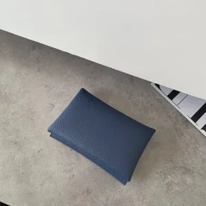 Close-up detail of the textured leather card holder in deep blue, showcasing fine grain.