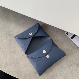Detailed view of the blue leather coin purse, featuring fine palm grain texture and snap closure.