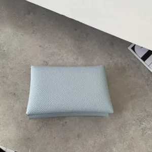 Detail shot of light blue genuine leather coin purse with classic palm grain texture design.