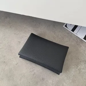 Black genuine leather card holder minimalist wallet with pebbled texture detail view.