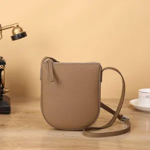Sac bandoulière vertical minimaliste en cuir marron pour téléphone et petit porte-monnaie.