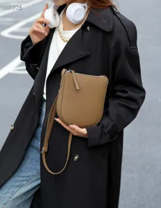 Détail de sac bandoulière téléphone vertical en cuir marron, petit sac simple femme.