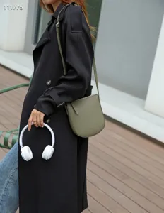 Vue de détail rapprochée du sac bandoulière vertical minimaliste pour femme en cuir olive.