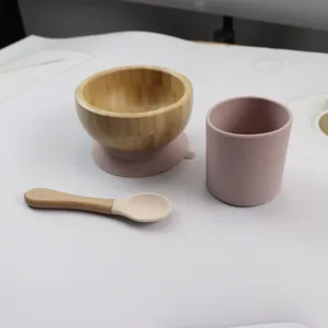 Detailed view of the baby wooden bowl with silicone suction base, cup and spoon set.