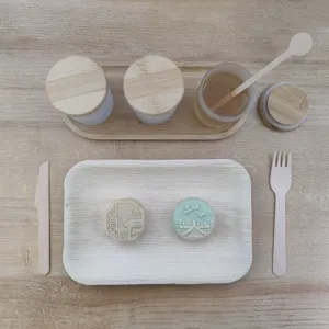 Detailed view of wooden tableware set, including wooden trays, honey stirrers, and cups.