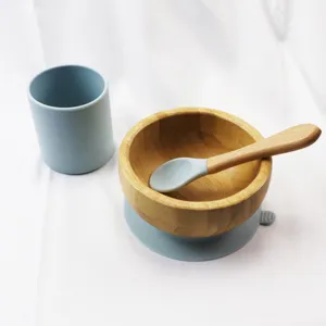 Blue silicone cup and wooden baby bowl set with suction base and spoon for toddlers.