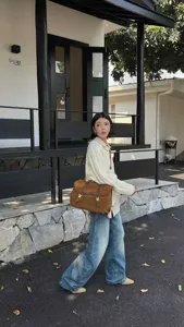 Detailed scene shot showing the vintage brown suede backpack worn by a model outdoors.