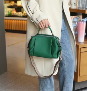 Green genuine leather top handle shoulder bag detailed view showing fine texture and sturdy strap.