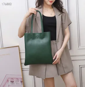 Dark green leather tote bag detail view, showing smooth texture and large daily capacity.